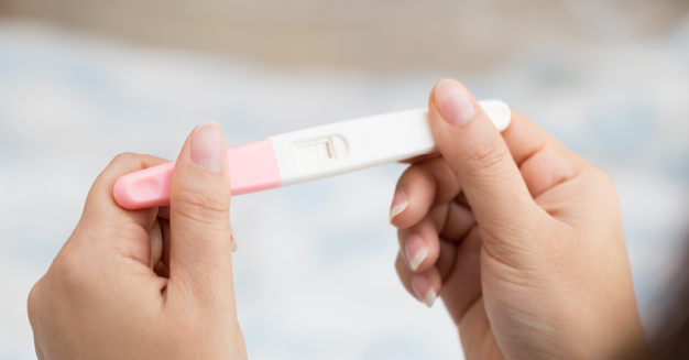 woman holding pregnancy test